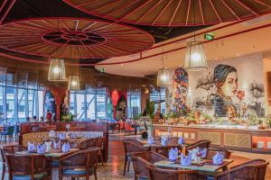 ニャチャンにあるINFINITY OCEAN PALACE PANORAMA Nha Trang Centerのテーブルと椅子とバーのあるレストラン