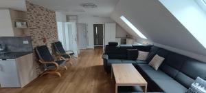 Una sala de estar con un sofá azul y una mesa. en Apartmán Jana, en Vysoké Mýto 7 fotos más