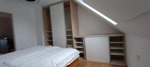 Habitación con cama y escalera con estanterías en Apartmán Jana, en Vysoké Mýto