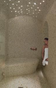 a man is standing in a bathroom with a bath tub at Grand Hotel Saint Michel in Paris