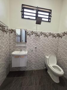 a bathroom with a toilet and a sink and a window at D Bukit homestay in Ketereh +16 photos