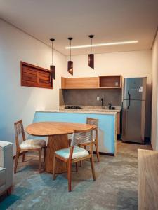 Una cocina con mesa y sillas y un refrigerador. en Morros da Barra chalé 05, en Barra Grande 8 fotos más