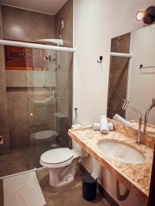 Un baño con inodoro, lavabo y ducha. en Morros da Barra chalé 05, en Barra Grande