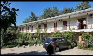 a car parked outside of a building with people on the balcony at Золотий Якор in Gribovka