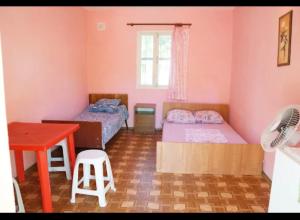 a bedroom with two beds and a table and a desk at Золотий Якор in Gribovka