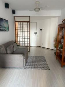 een woonkamer met een grijze bank en een deur bij Top 40 - Apartamento na Barra vista do mar e lagoa in Rio de Janeiro