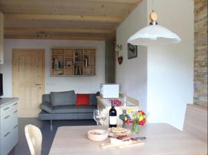 a living room with a table with a bottle of wine at Appartamenti Chantal in San Martino in Badia
