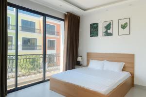 une chambre avec un lit et une grande fenêtre dans l'établissement Charm Homestay Hải Phòng - Tự Check-in 24h - Gần VinWonders Vũ Yên, à Binh Hai 17 autres photos