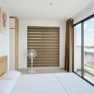 une chambre avec une porte équipée d'un ventilateur et une fenêtre dans l'établissement Charm Homestay Hải Phòng - Tự Check-in 24h - Gần VinWonders Vũ Yên, à Binh Hai