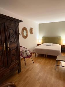 a bedroom with a bed and a cabinet and a chair at Vue Mer Santa Clara 3 in La Baule