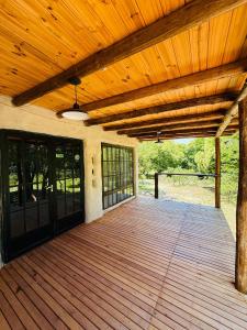 une véranda en bois avec un plafond en bois et une terrasse en bois dans l'établissement Tierra de Arroyo, Mallin-Tanti, à Tanti