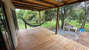 un porche de maison avec un hamac et un banc dans l'établissement Tierra de Arroyo, Mallin-Tanti, à Tanti