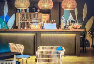 a bar with wicker chairs and a counter with lights at Camping Del Mar 64, Mobile Home Premium, 2 chambres, 4 personnes, 1 Salles de Bain, bord de mer in Argelès-sur-Mer