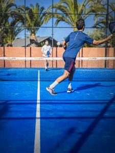 a man swinging a tennis racket on a tennis court at Camping Del Mar 64, Mobile Home Premium, 2 chambres, 4 personnes, 1 Salles de Bain, bord de mer in Argelès-sur-Mer +22 photos