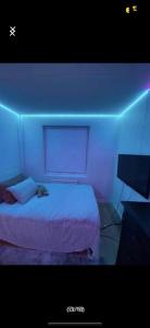 a bedroom with a bed with a blue light at Guesthouse Platina centrum in Oslo
