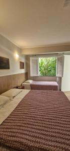 a large bedroom with two beds and a window at Ecopousada Miriti in Belém