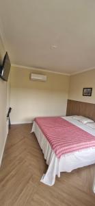 a bedroom with a large bed with a red blanket at Ecopousada Miriti in Belém