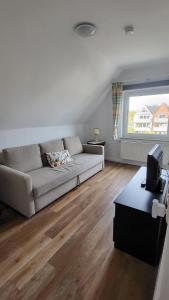 a living room with a couch and a window at Ankerplatz Lichtblick in Travemünde