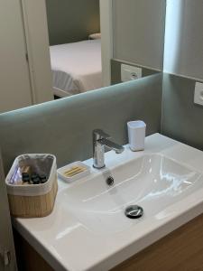 a white sink in a bathroom with a mirror at IsabellaGuestHouse in Chiusa di Pesio +32 photos