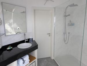 ein weißes Badezimmer mit Dusche und Waschbecken in der Unterkunft Ferienhaus MAWO 4 Sterne in Andernach + 9 Fotos