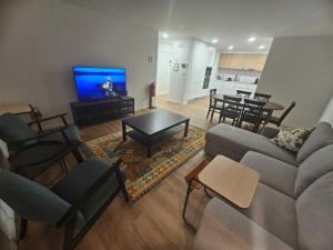 a living room with a couch and a flat screen tv at Apartamento Sonho Jardim in Ponta Delgada