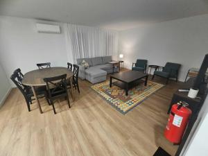 a living room with a couch and a table and chairs at Apartamento Sonho Jardim in Ponta Delgada