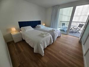 a bedroom with two beds and a balcony at Apartamento Sonho Jardim in Ponta Delgada