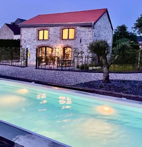 een huis met een zwembad ervoor bij Le Gîte du Pèlerin avec piscine in Florennes