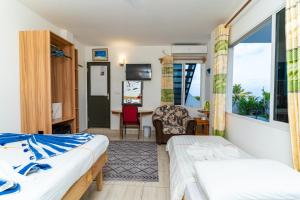 a hotel room with two beds and a desk at Olhumathi View Inn in Ukulhas