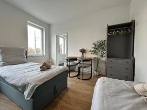 a bedroom with a bed and a desk and a table at GeBa Bed & Single Rooms in Leipzig