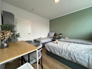 a living room with two beds and a table at GeBa Bed & Single Rooms in Leipzig