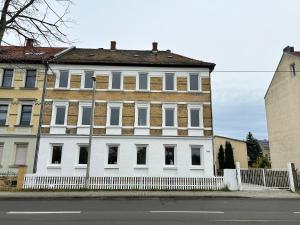 a large white building with a white fence at GeBa Bed & Single Rooms in Leipzig