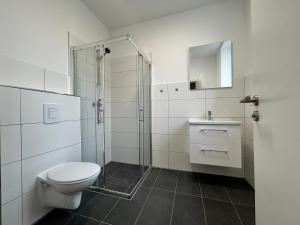 a white bathroom with a toilet and a shower at GeBa Bed & Single Rooms in Leipzig +12 photos