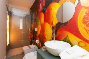 a bathroom with a sink and a painting on the wall at History Suite Riccione in Riccione +100 photos