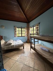 een kamer met 2 bedden, een tafel en ramen bij Casa Paraíso do Ribeirão in Lençóis +57 foto's