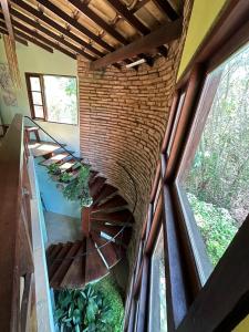 a spiral staircase in a house with a brick wall at Casa Paraíso do Ribeirão in Lençóis +45 photos