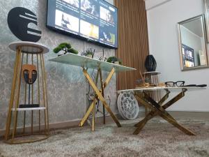 a table and two stools in a room with a tv at Sages Place in Gaborone