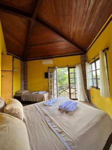 a bedroom with a large bed with two towels on it at Casa Paraíso do Ribeirão in Lençóis