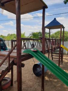 a playground with a green slide and a gazebo at Sages Place in Gaborone