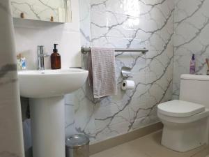 a white bathroom with a sink and a toilet at Sages Place in Gaborone +15 photos