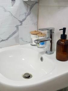 a bathroom sink with a soap dispenser on it at Sages Place in Gaborone