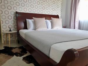 a bedroom with a large bed with white pillows at Sages Place in Gaborone