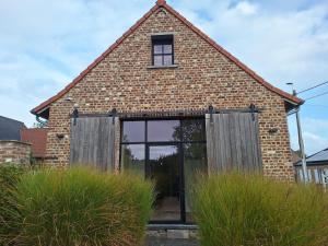 a brick house with a large window on the front of it at Vakantiehuis 6 personen-rustig en karaktervol in Geraardsbergen