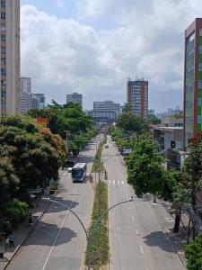 a city street with a bus on the road at Quarto aconchegante na melhor localização do Recife in Recife