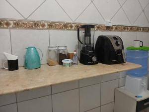a counter with a blender and other items on it at Quarto aconchegante na melhor localização do Recife in Recife