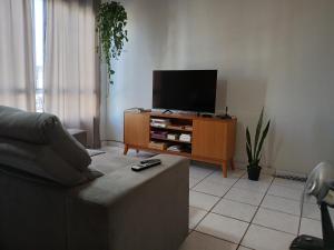 a living room with a couch and a flat screen tv at Quarto aconchegante na melhor localização do Recife in Recife