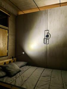 Un dormitorio con una cama y una luz en la pared. en EB5 Escape Tzununa, Lake Atitlan Room #3 - two minute walk to the Lake, en Tzununá