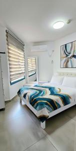 a bedroom with a large bed with a colorful blanket at Tiberias 512 in Tiberias