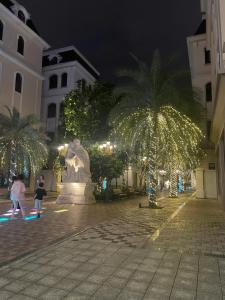 a courtyard with a fountain and palm trees at night at Nhà nghỉ 79 Ocean Park 2 in Ðình Loan +11 photos