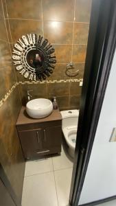 a bathroom with a sink and a mirror and a toilet at casabosque habitacion301 in Bogotá